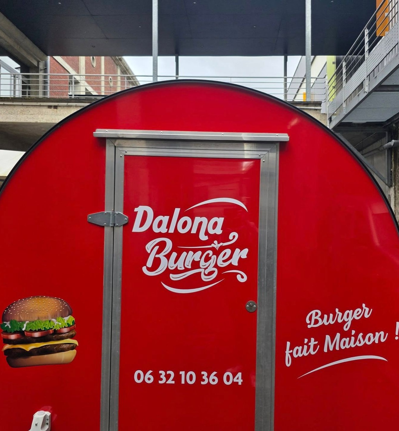 Camionnette rouge de DALONA BURGER, une image de burger et un numéro de téléphone sont inscrits.