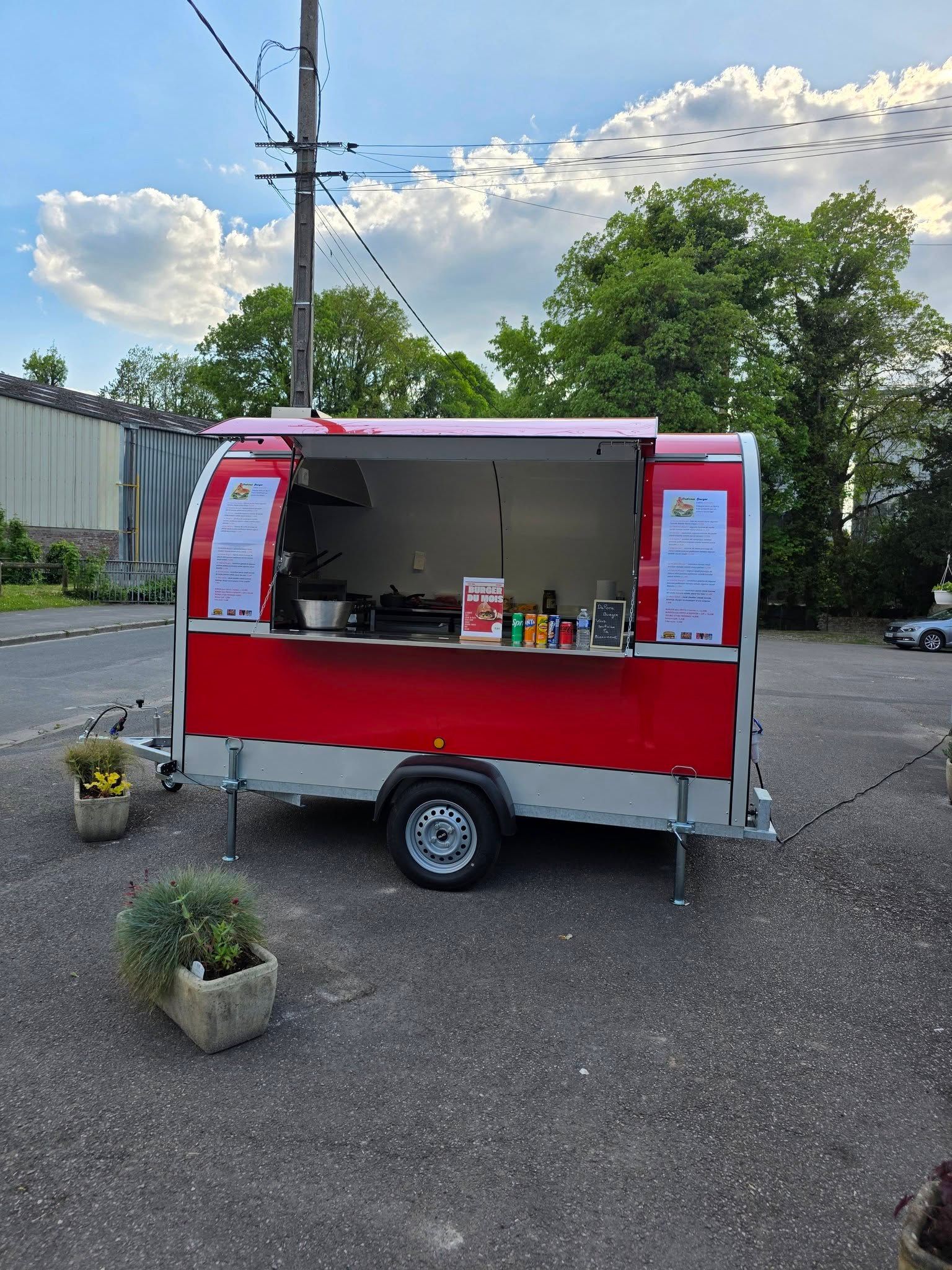 Le food truck de DALONA BURGER avec fenêtre de service ouverte, stationnée à l'extérieur.