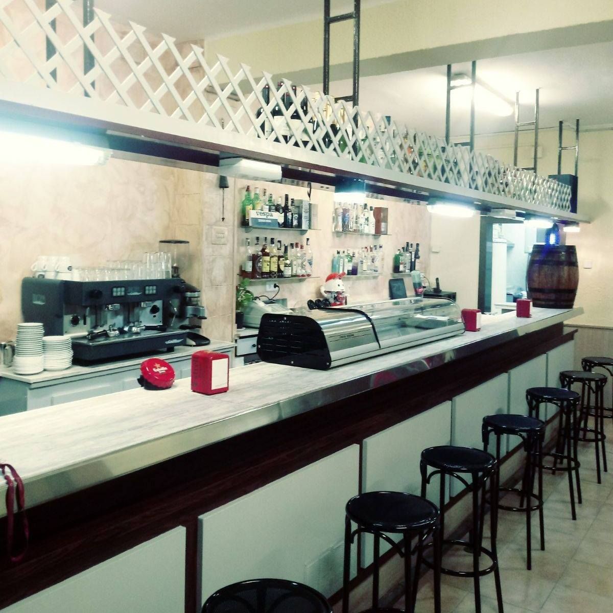 Un restaurante con una barra larga y taburetes