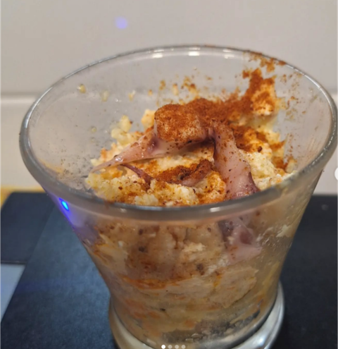 Un primer plano de un vaso lleno de comida sobre una mesa.