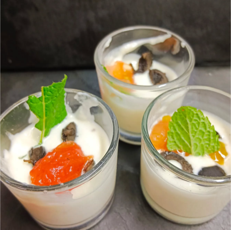 Tres vasos de yogur con fruta y hojas encima