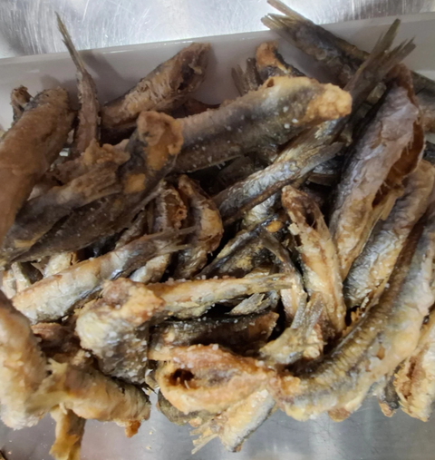 Una pila de pescado frito está sobre una mesa
