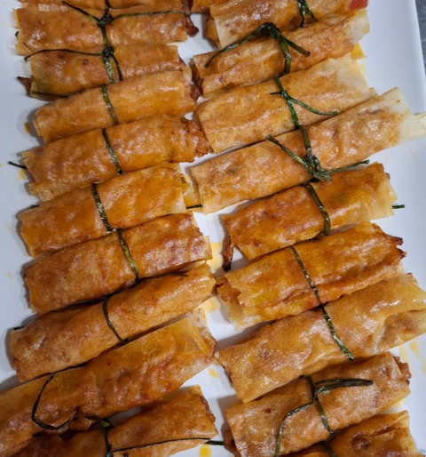 Un plato blanco cubierto con un montón de panecillos fritos
