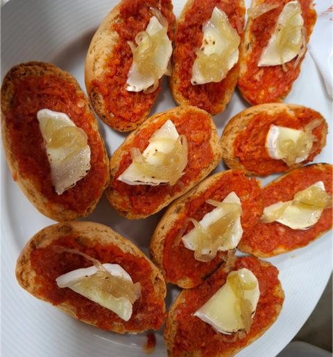Un plato blanco cubierto con rebanadas de pan y salsa de tomate.