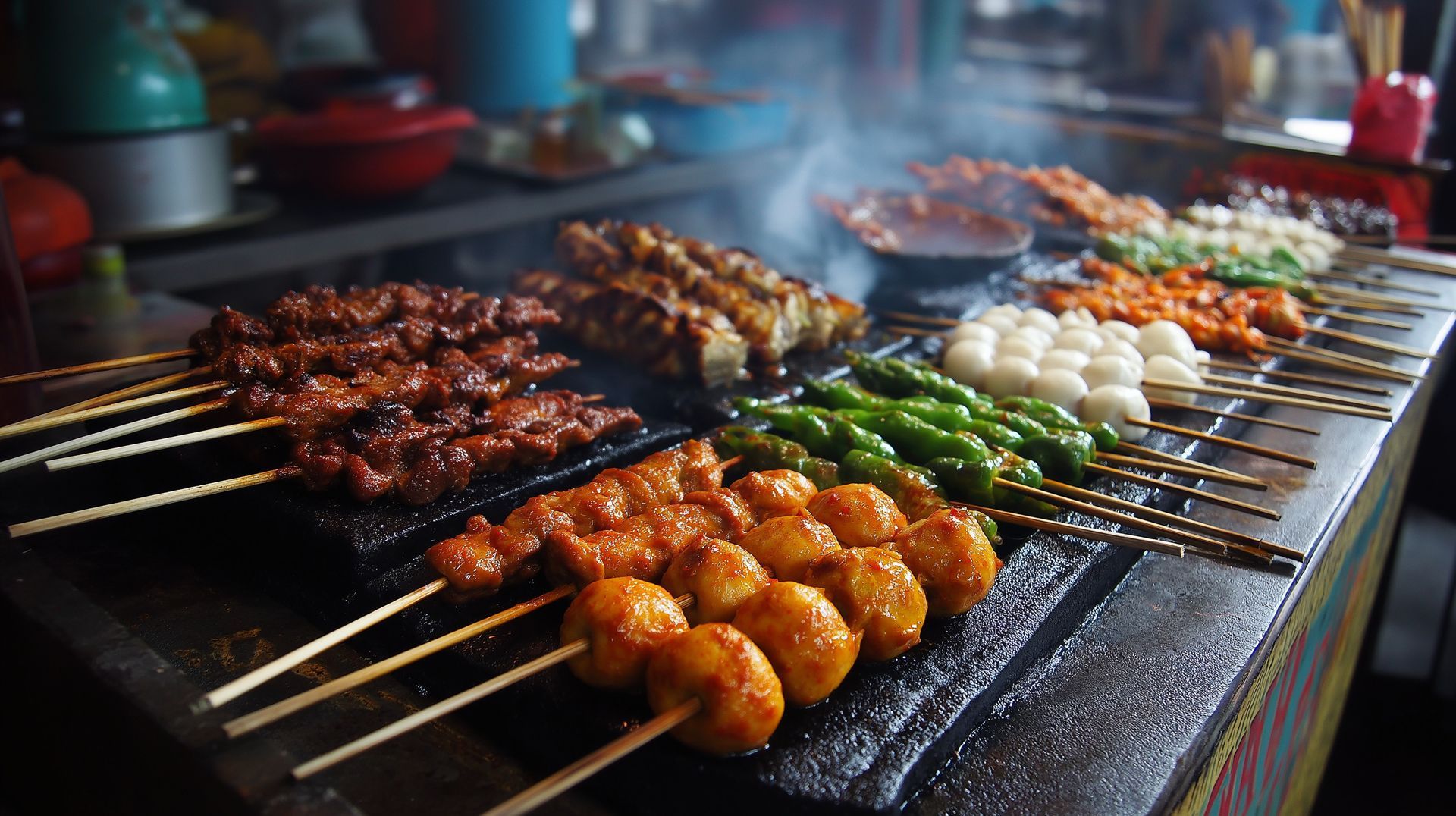 Brochettes de viande et de légumes grillées sur une surface chaude, de couleurs variées, d'où s'élève de la fumée.