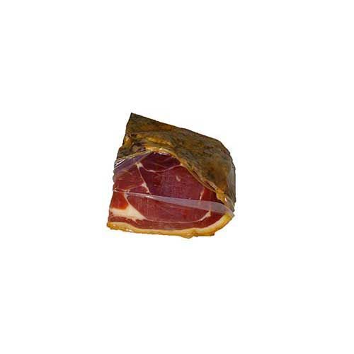 Un trozo de jamón reposa sobre una superficie blanca.
