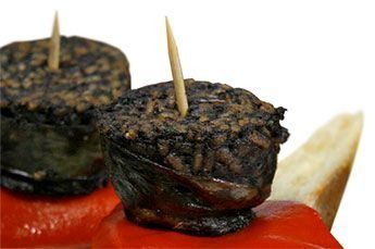 Un primer plano de dos trozos de comida con palillos en ellos en un plato.