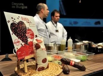 Dos hombres están de pie detrás de una mesa con un cartel que dice 'rioba'.