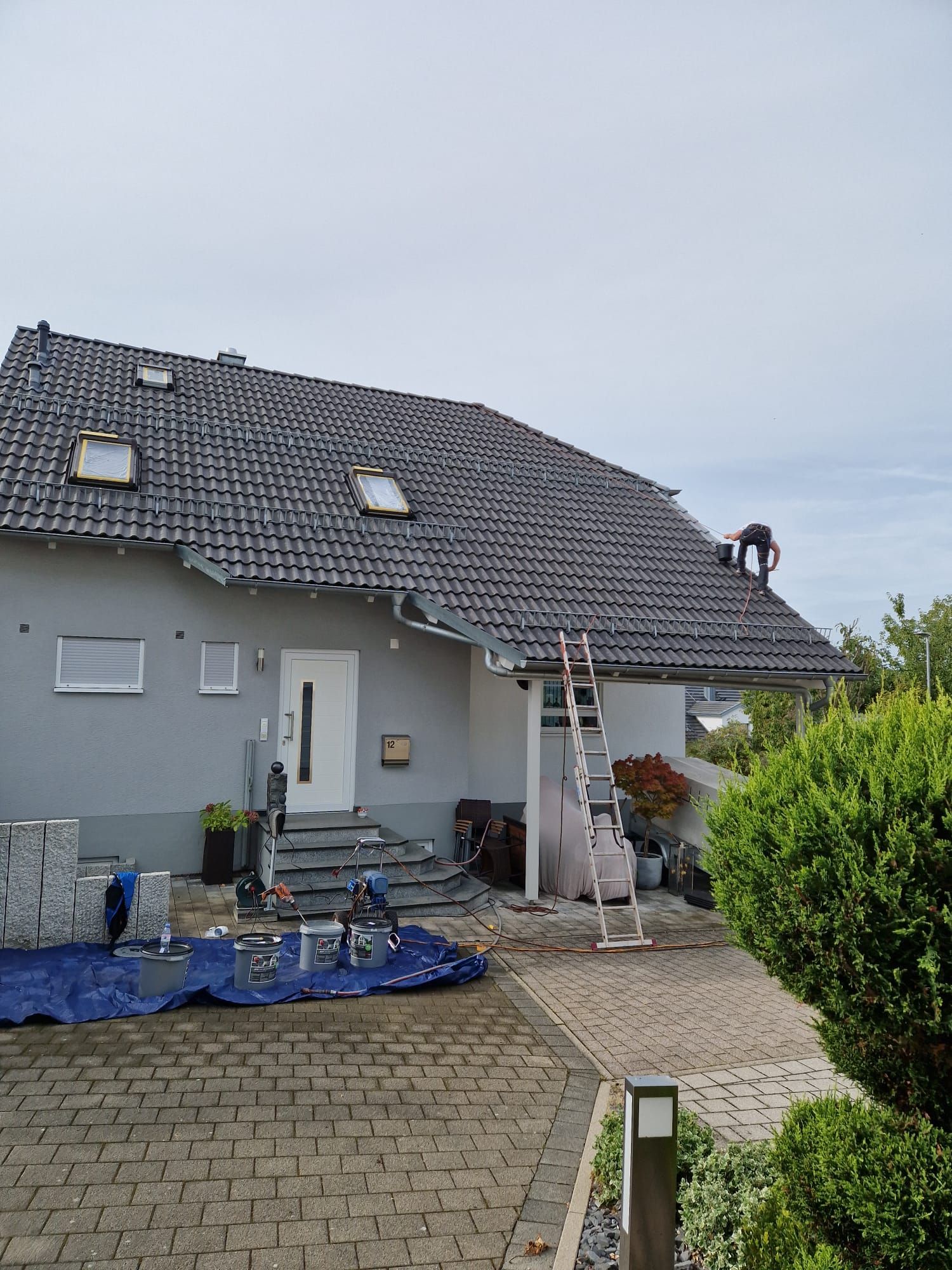 Ein Haus mit einer Leiter davor wird gestrichen