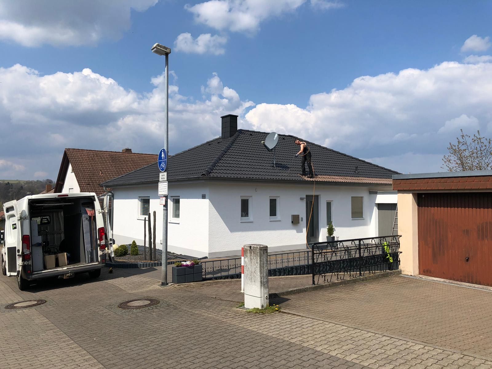 Ein Mann steht auf dem Dach eines weißen Hauses