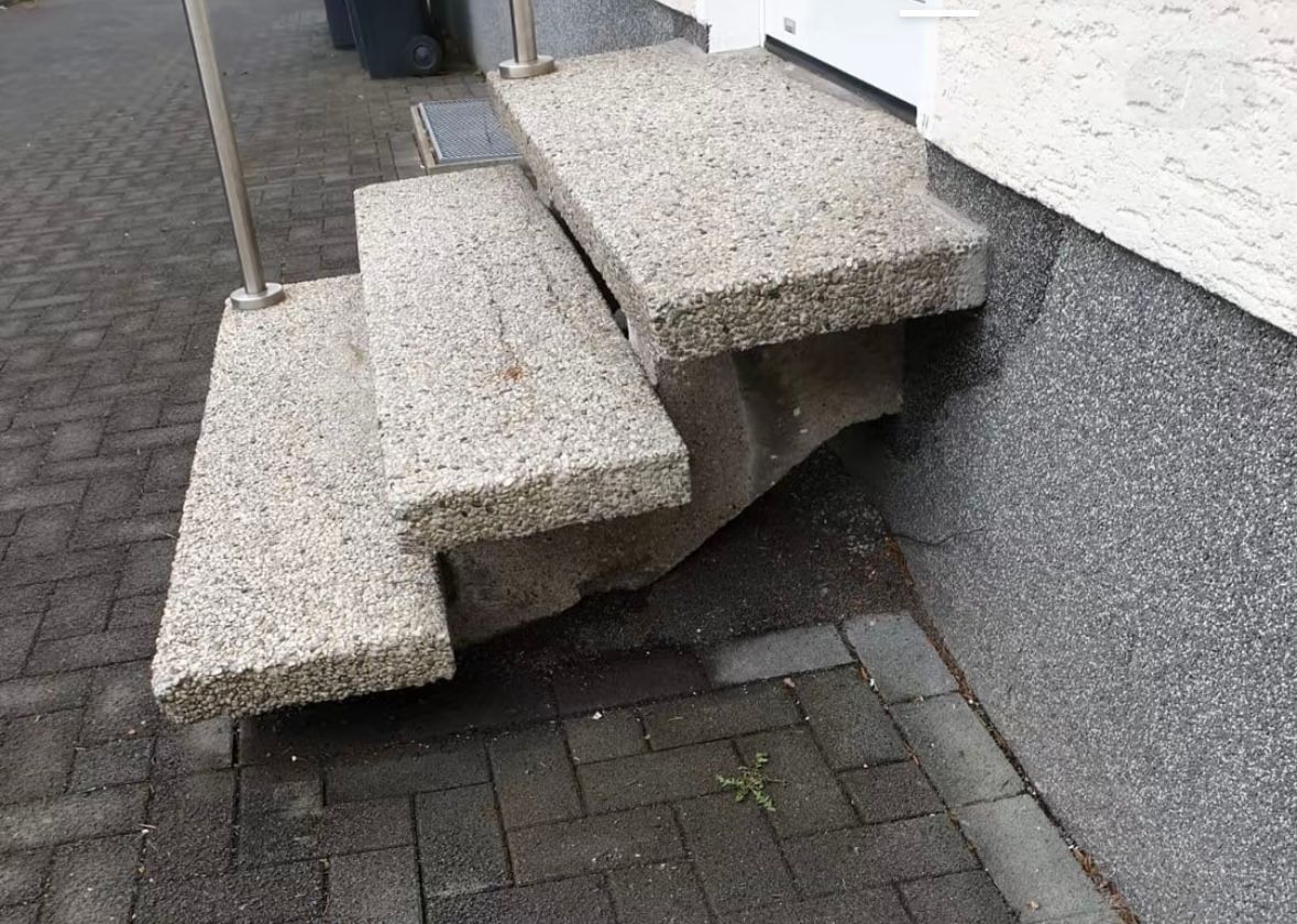 Eine Treppe, die auf einem Gehweg zu einem Gebäude hinaufführt