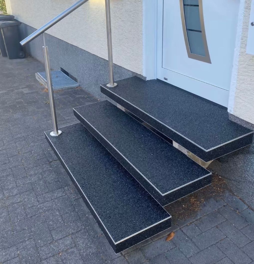 Eine schwarze Treppe, die zu einer weißen Tür führt