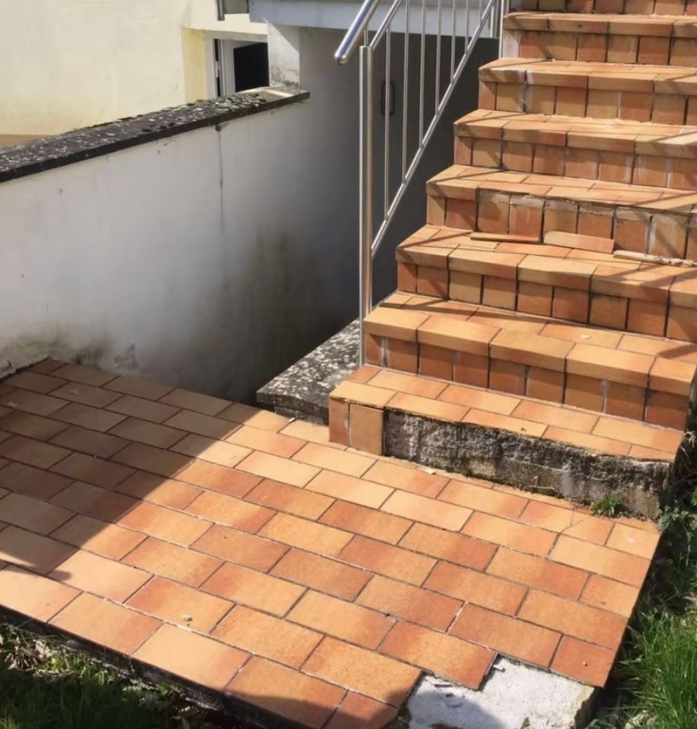 Eine Reihe von Ziegelsteintreppen, die in einen Keller führen