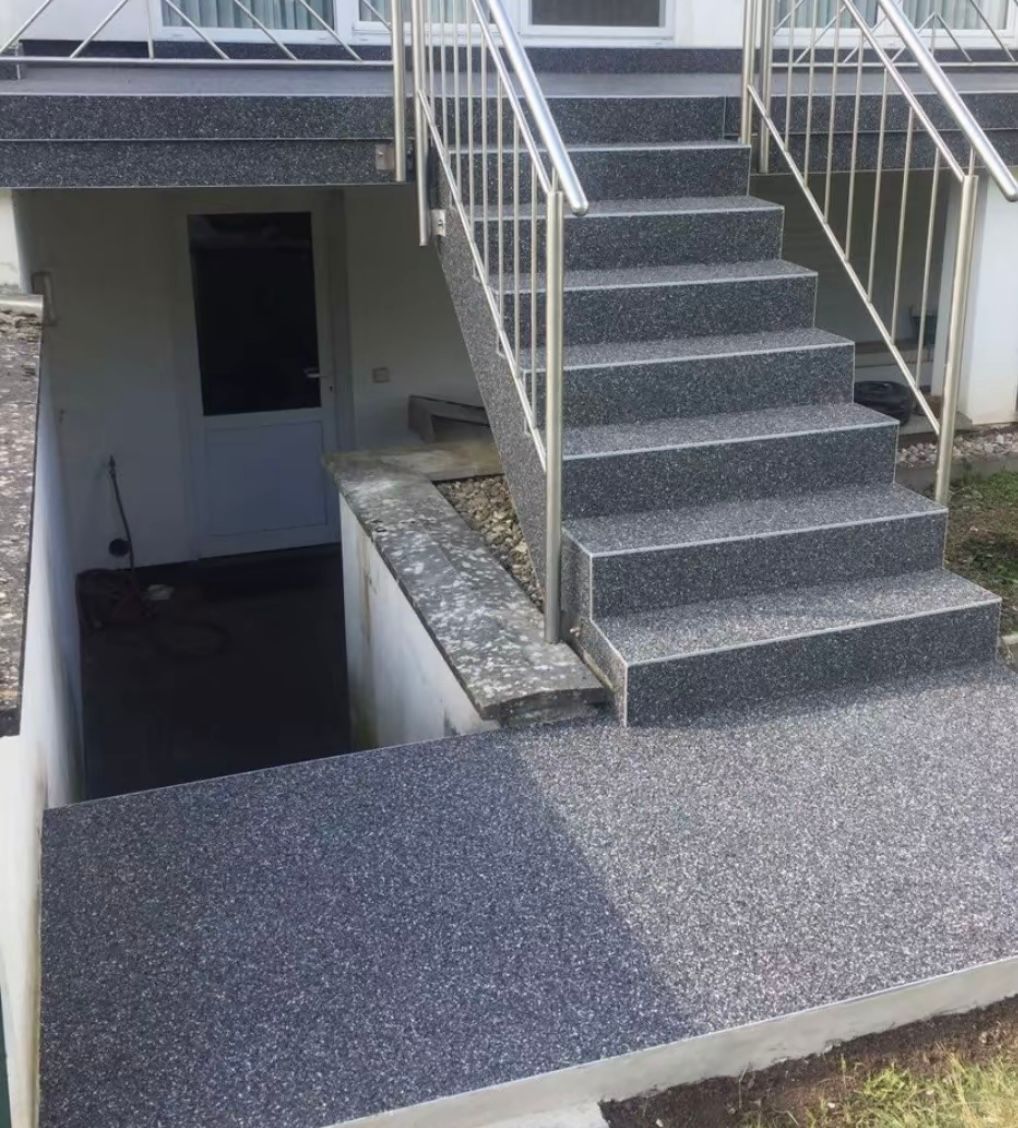 Eine Treppe mit Metallgeländer, die in einen Keller führt