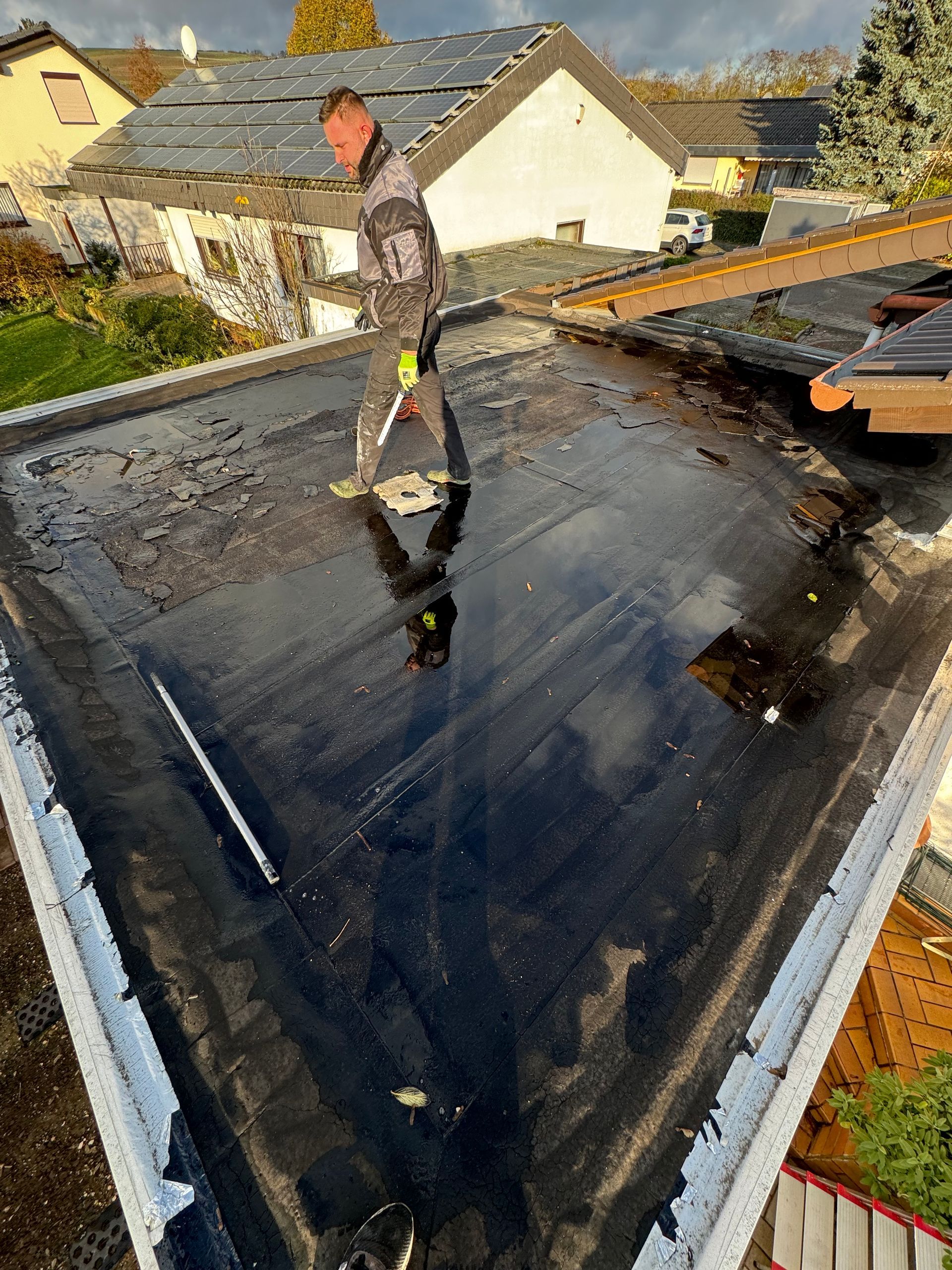 Ein Mann steht auf einem schwarzen Flachdach