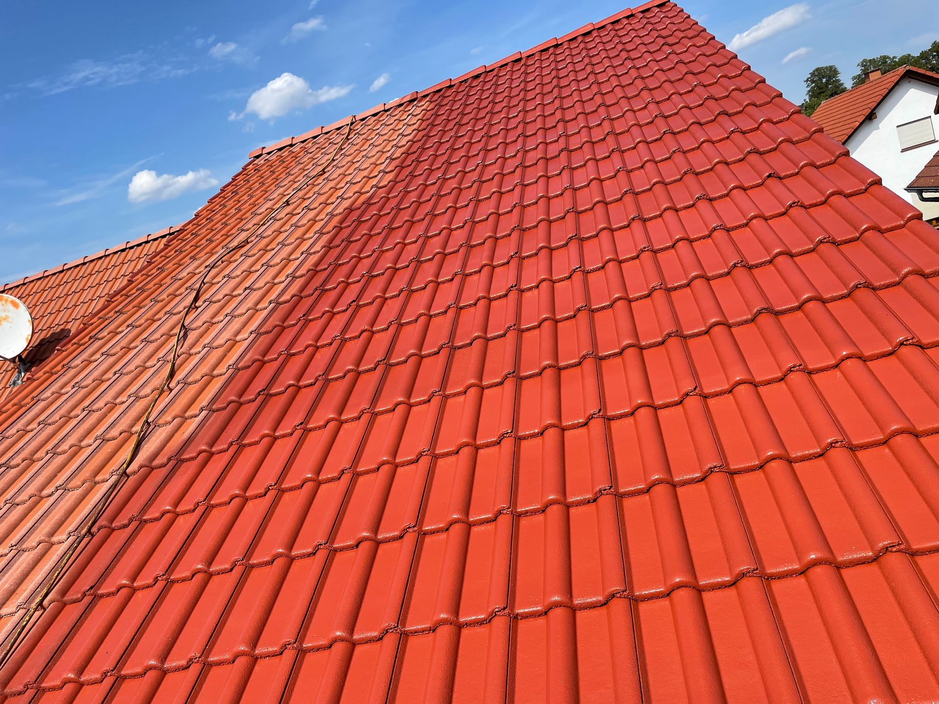 Ein rotes Ziegeldach mit einem blauen Himmel im Hintergrund