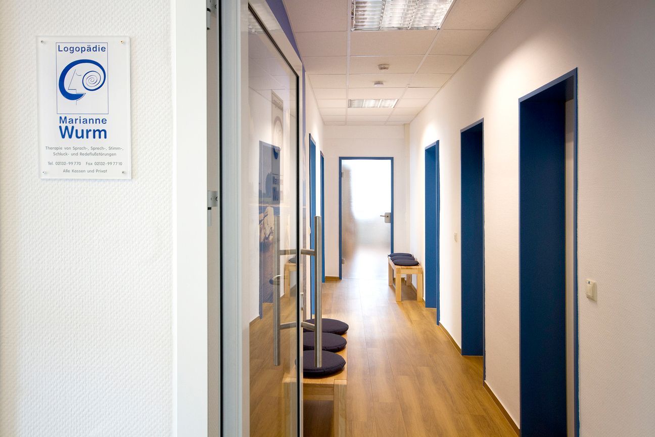 Therapeutin die mit Mutter und Kind die Buchstaben anhand von Kärtchen übt.