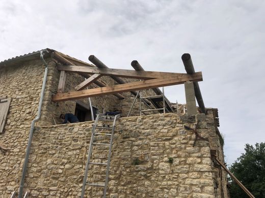 Une maison ancienne avec une charpente en bois apparente