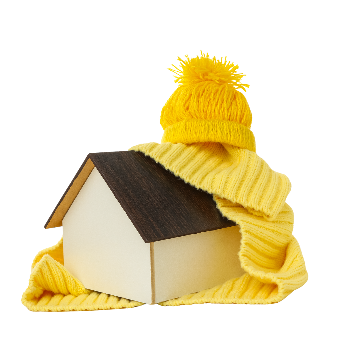 Un bonnet jaune tricoté recouvre une petite maquette de maison au toit sombre sur fond blanc.