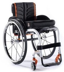 Ein schwarz-orangefarbener Rollstuhl steht auf einer weißen Fläche.