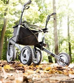 Ein Spaziergänger sitzt im Wald auf einem Blätterhaufen.