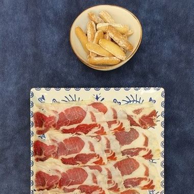 Un plato azul cubierto con conchas y frijoles sobre una mesa.