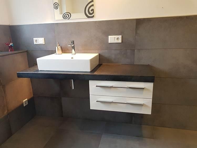 Ein Badezimmer mit Waschbecken und Spiegel an der Wand