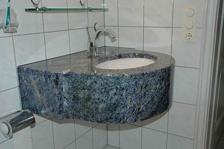 Ein Badezimmerwaschbecken mit blauer Arbeitsplatte und einem weißen Waschbecken