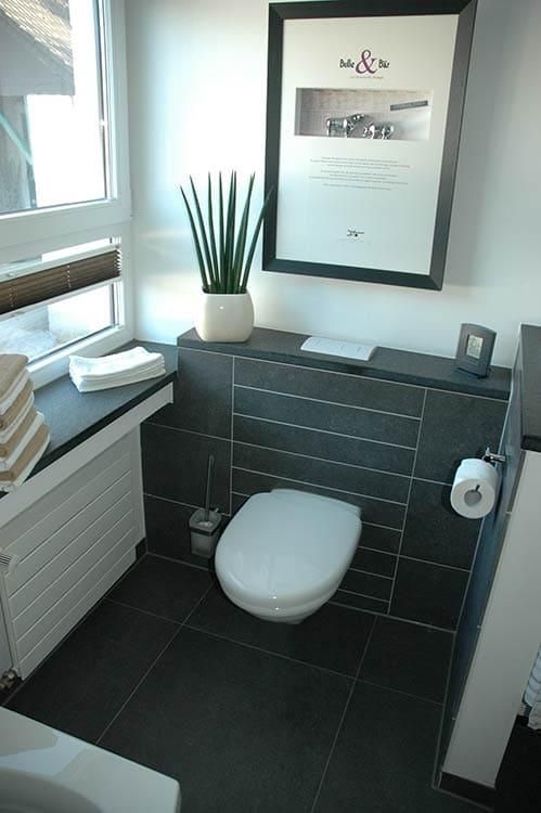 Ein Badezimmer mit Toilette und einem Bild an der Wand