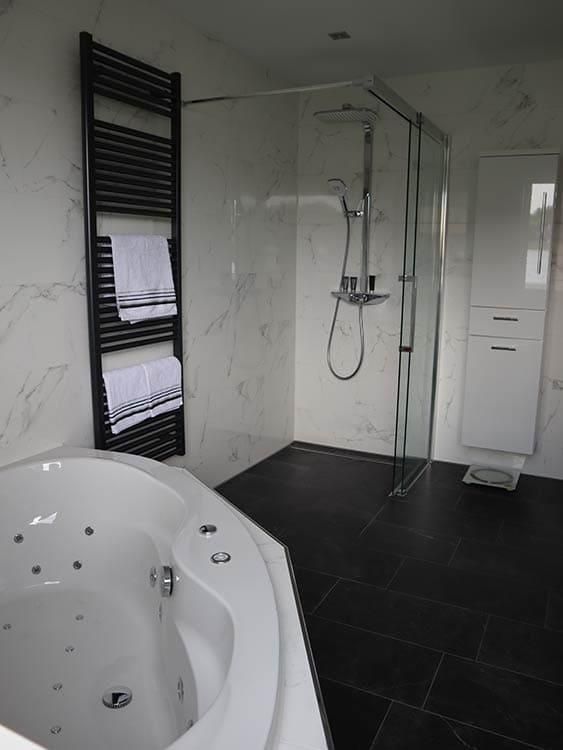 Ein Badezimmer mit Whirlpool und ebenerdiger Dusche