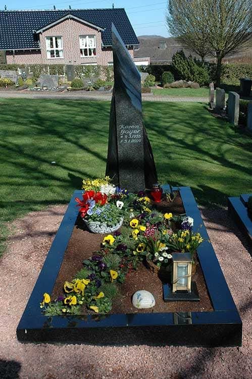 Ein Grab mit Blumen und einem Bild darauf