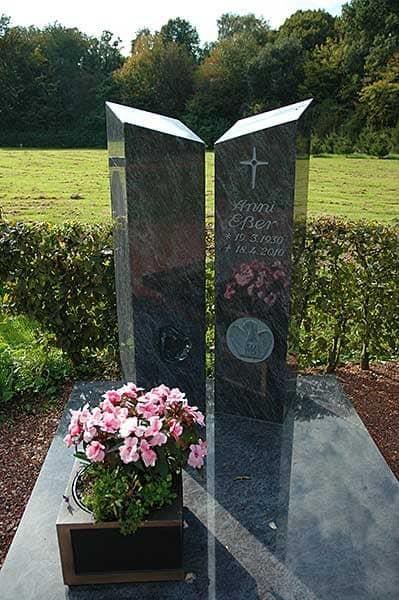 Ein Grab mit Blumen und einem Kreuz darauf