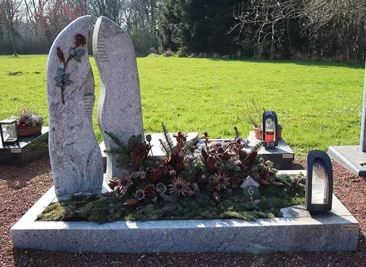 Ein Grab auf einem Friedhof mit Blumen darauf