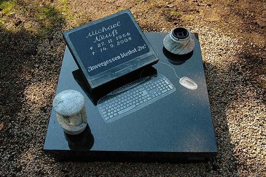 Ein Grabstein mit einer Tastatur und einer Vase darauf