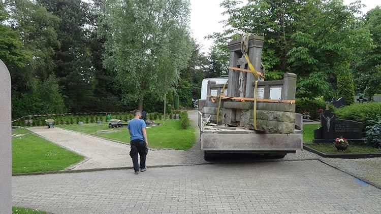 Ein Mann läuft auf einem Friedhof vor einem großen Lastwagen her.