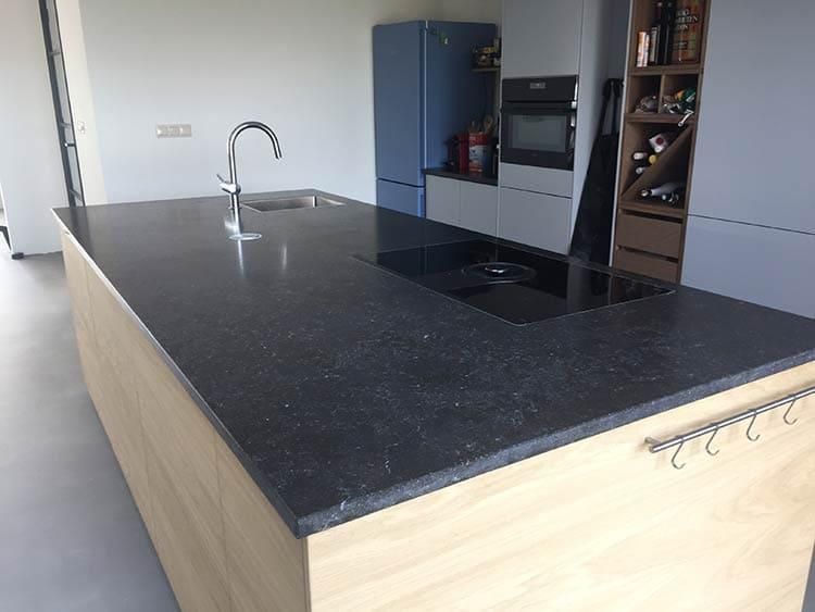 Eine Küche mit einer großen schwarzen Arbeitsplatte und einer Spüle.