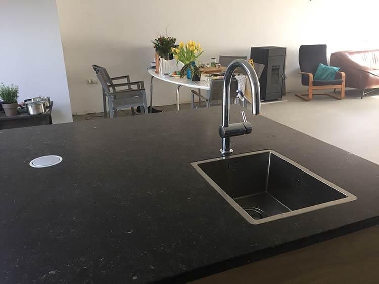 Eine Küchenspüle steht auf einer Arbeitsplatte in einem Wohnzimmer.
