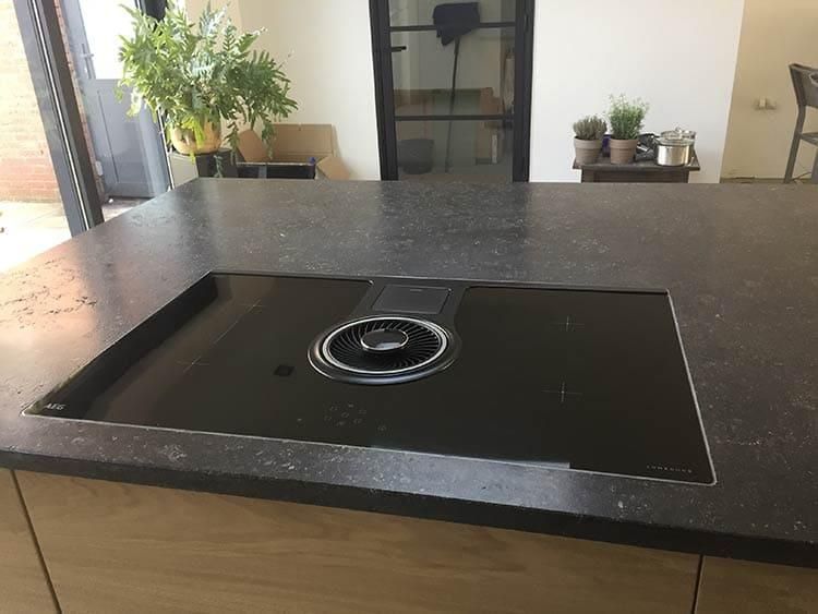 Ein schwarzer Herdofen steht auf einer Arbeitsplatte in einer Küche.