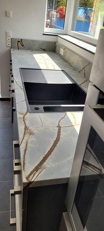 Eine Küche mit Spüle, Herd und Fenster.