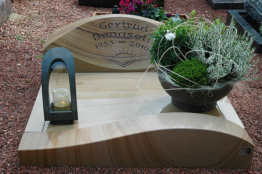 Ein Grab mit einer Kerze und einer Vase mit Blumen