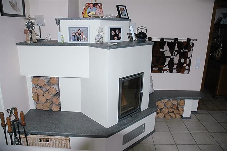 Ein Wohnzimmer mit Kamin und Bildern an der Wand