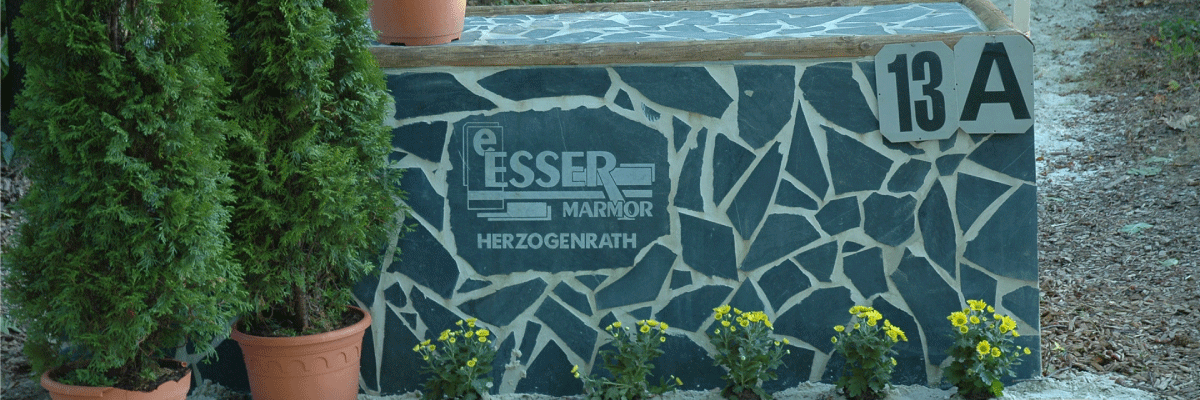 Eine Steinmauer mit der Nummer 13 a darauf