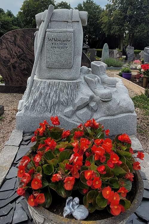 Ein Grab mit roten Blumen davor