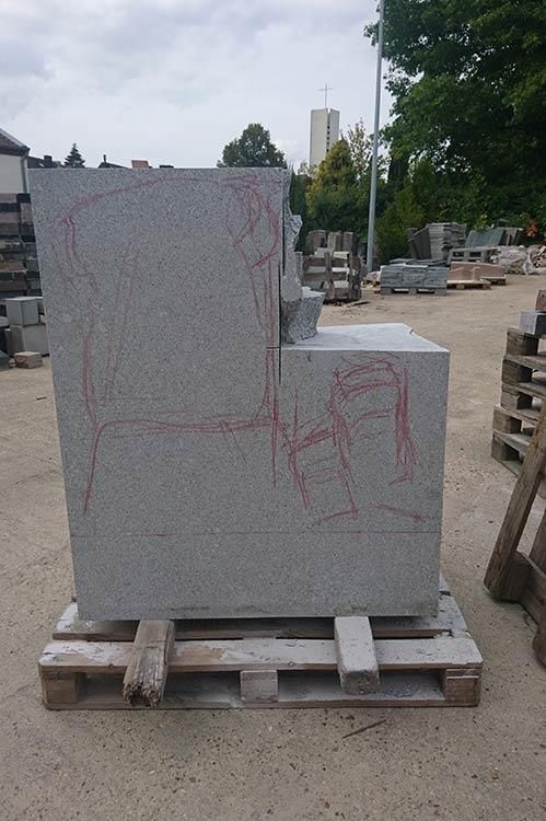 Eine große Steinskulptur sitzt auf einer Holzpalette.