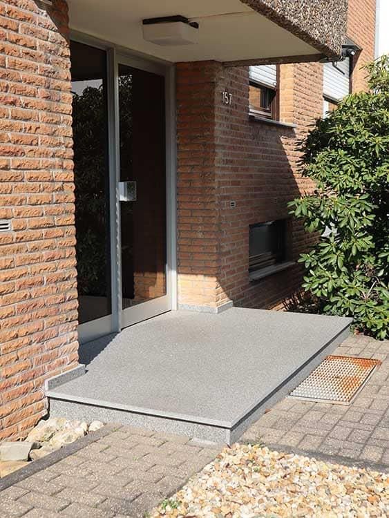 Ein Backsteingebäude mit einer Tür und einer Rampe, die dorthin führt.