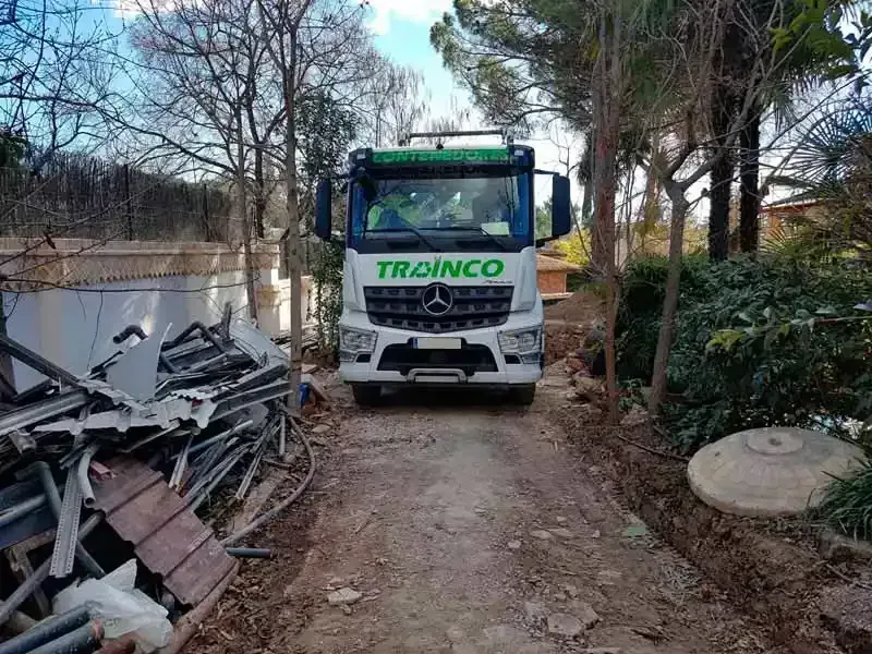 Un camión está estacionado al costado de un camino de tierra.