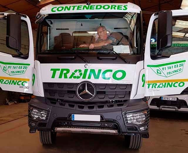 Un hombre conduce un camión Mercedes con las puertas abiertas.