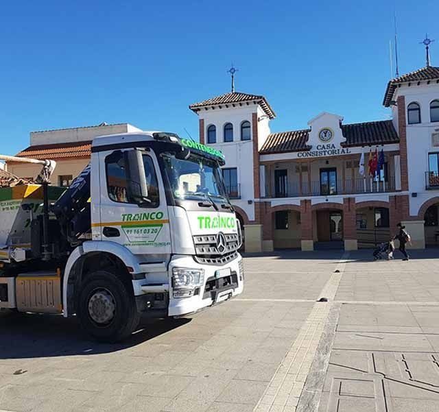 Un camión con la palabra blanco en el costado está estacionado frente a un edificio.