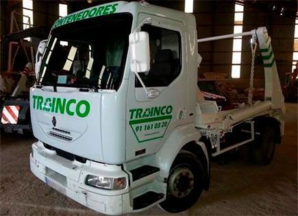 Un camión blanco de Trainco está estacionado en un almacén.