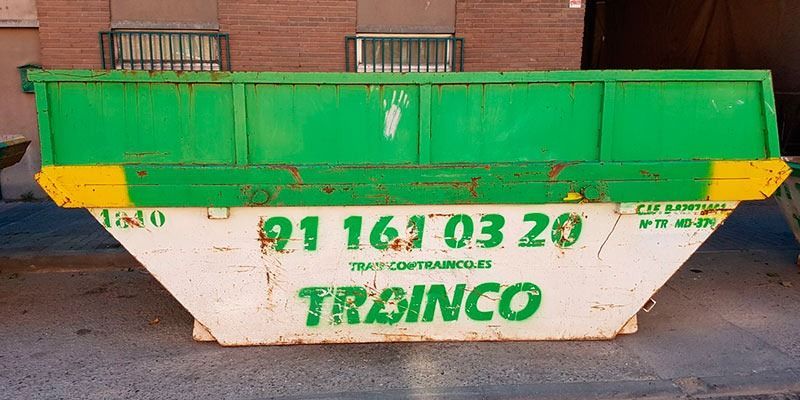 Un contenedor de basura verde y blanco con la palabra trainco en él